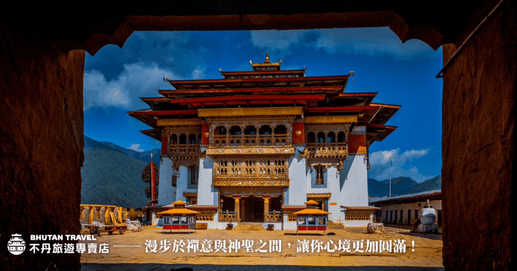 這張圖片展示了不丹崗提貢巴寺的寺廟入口，建築風格具有不丹獨特的文化特色。寺廟前方有典型的傳統柱子和裝飾，背景呈現出令人驚嘆的藍天和自然景觀。這幅圖片營造出一種沉浸在禪意與神聖之間的氛圍，是不丹旅遊的一個重要象徵。