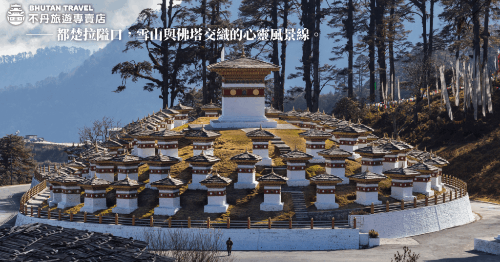 這張圖片呈現不丹著名的都楚拉隘口（Dochula Pass）壯觀的108座佛塔（Chortens），佛塔環繞於山坡之上，層層堆疊，極具規律美感。遠方薄霧籠罩雪山林木，佛塔在晨光照映下更顯潔白神聖。周圍樹林與飄揚的經幡為景色添上靈性氣息。這裡結合自然壯麗與宗教聖潔，是連結心靈與大地的重要地標，也是前往不丹旅程中不可錯過的精神景點。