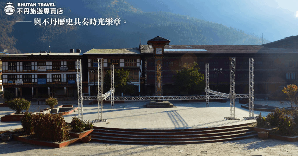 這張圖片展示了不丹的歷史表演廣場，背景是典型的不丹建築風格，並顯示了廣場的準備設施。此地點常常用來舉行不丹的傳統表演和慶典，圖中展示的舞台設施和環境融合了現代設計與不丹的歷史文化氛圍。